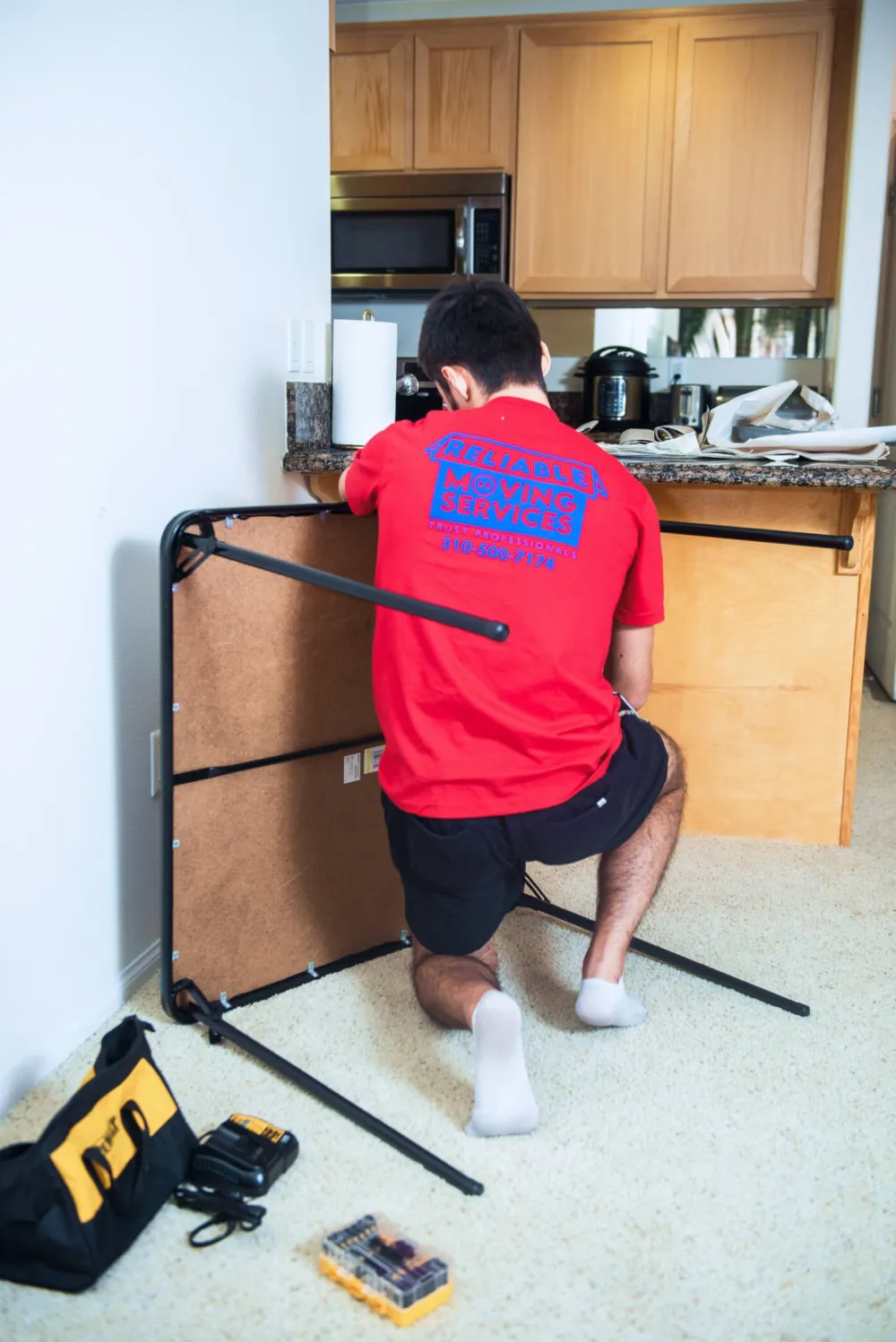 Reliable Moving Services crew wrapping and moving furniture on a Los Angeles move.