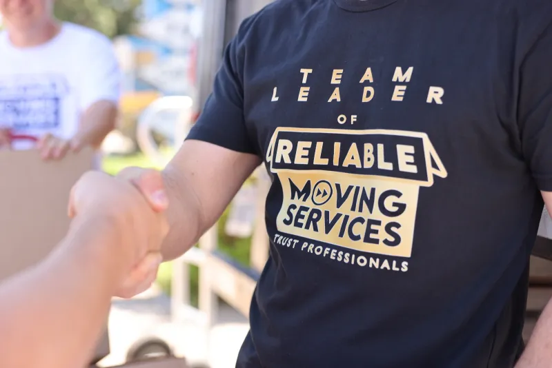Reliable Moving Services mover with branded boxes on a Los Angeles job.