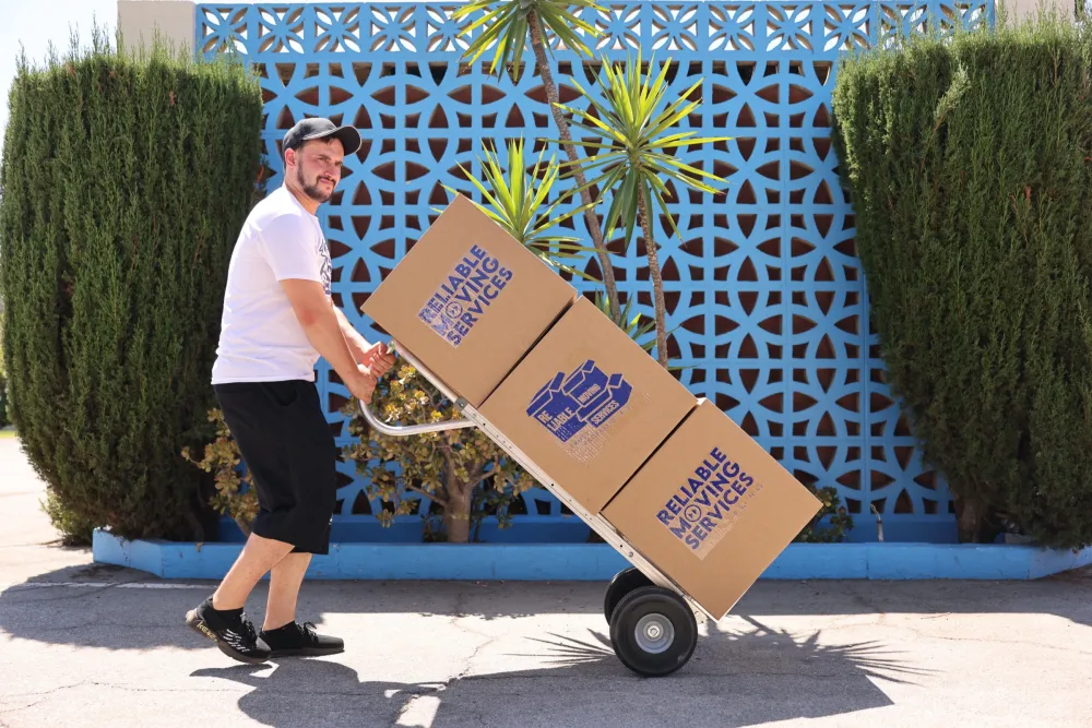 Reliable Moving Services crew with branded boxes — transparent, up-front pricing.
